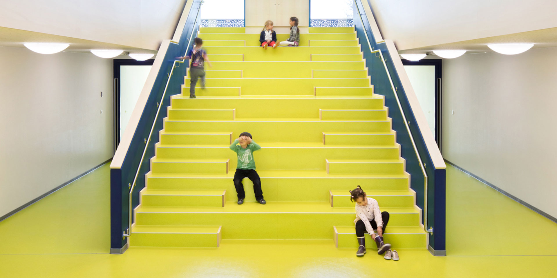 Kinder auf der Treppe der Kita im Grünen - dem Herzstück des Gebäudes